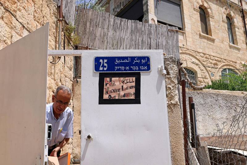 A poster against Israeli eviction orders is seen hanging on the gate of a Palestinian house in the Sheikh Jarrah neighbourhood of occupied east Jerusalem on May 5, 2021. - Israeli Jews backed by courts have taken over houses in Sheikh Jarrah in east Jerusalem on the grounds that Jewish families lived there before fleeing in Israel's 1948 war for independence. The claimants seek to evict a total of 58 more Palestinians, according to the watchdog group Peace Now, and  Israel's Supreme Court is set to announce a decision for four of those families on May 6, 2021. (Photo by Emmanuel DUNAND / AFP)