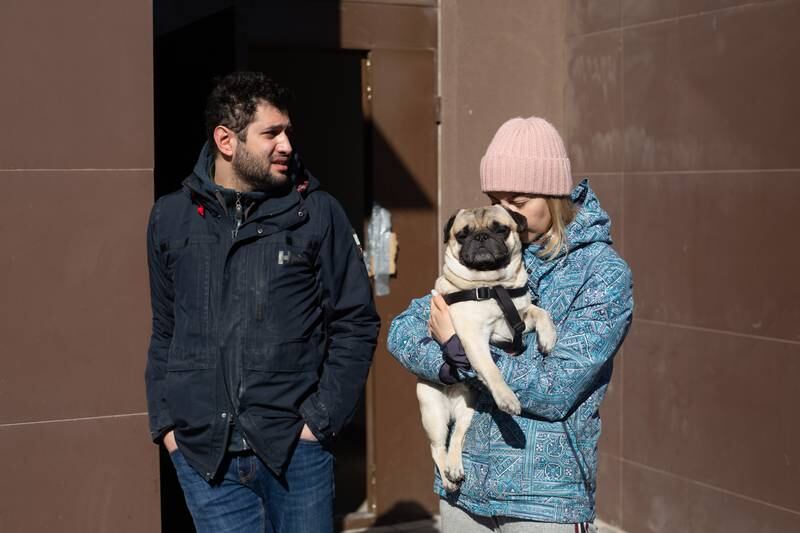 Samir Khuder, Anna Ponomaryova and their dog, Fedya, enjoy the fresh air after a night spent in the basement they used as a bomb shelter after a rocket hit a shopping mall in Kyiv. Getty