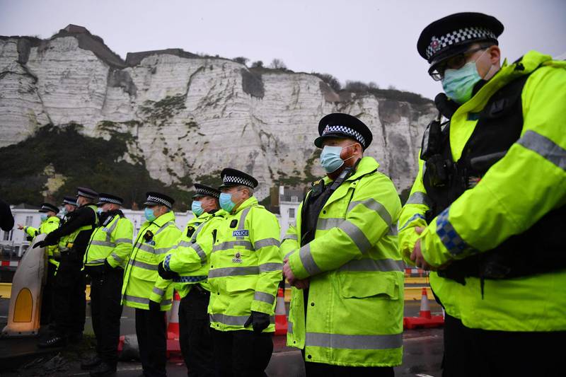 Police officers form a cordon at the entrance to the port in Dover, in Kent, south east England, after the UK and France agreed a protocol to reopen the border to accompanied freight arriving in France from the UK.  France and Britain reopened cross-border travel after a snap 48-hour ban to curb the spread of a new coronavirus variant threatened UK supply chains. Accompanied frieght will now be allowed to cross the channel from the port of Dover but all lorry drivers will require a lateral flow test and a negative Covid-19 result before the travel. AFP