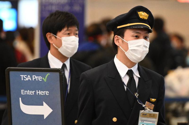 (FILES) In this file photo airline pilots wearing face mask arrive at TSA PreCheck for an outbound flight at Los Angeles International Airport, March 13, 2020.  Mask wearing, temperature controls, disinfection of aircraft: the International Civil Aviation Organization on June 1, 2020 published a series of health recommendations for a pandemic-hit airline industry as it relaunches air travel. The protocol was drawn up by an international task force formed by the Montreal-based ICAO with the help of other UN agencies like the World Health Organization and the powerful International Air Transport Association (IATA). / AFP / Robyn Beck
