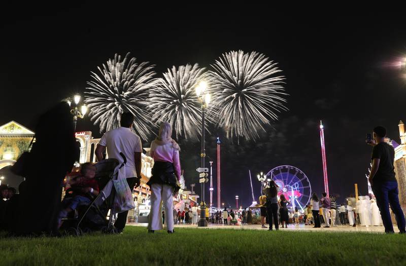 epa08773412 Visitors look on fireworks at the Global Village in Dubai, United Arab Emirates, 25 October 2020. The 25th edition of the Global village is running from 25 October 2020 till 18 April 2021. This edition is including 78 cultures represented in 26 pavilions and 3,500 outlets with taking all safety precautions to avoid the spreading of COVID-19.  EPA/ALI HAIDER