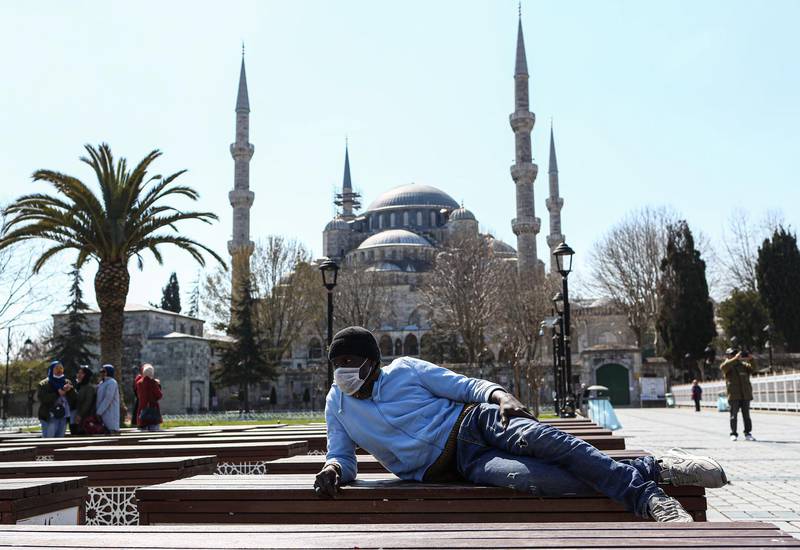 A man wearing a protective face mask rests in front of the Sultanahmet Mosque in Istanbul, Turkey.  EPA