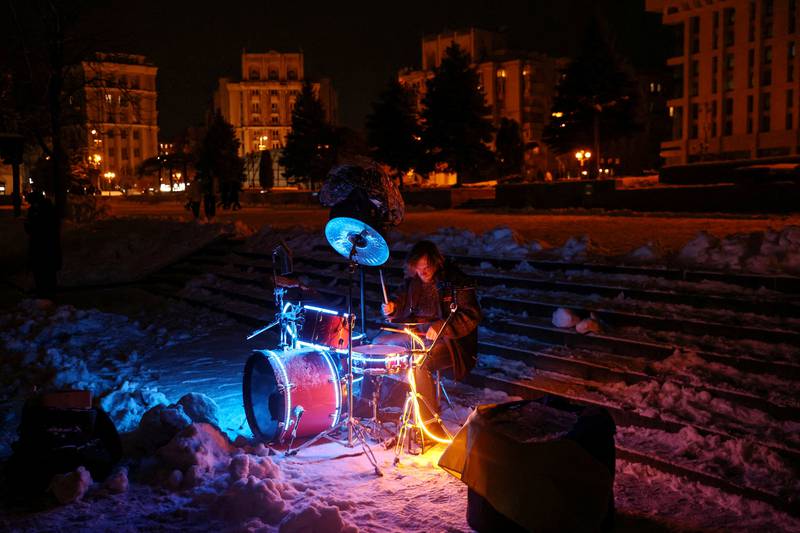 A street musician plays during snowfall as power outages continue in Kyiv, Ukraine. Reuters