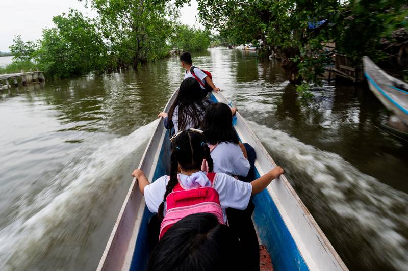 Pupils ride a boat to school in Macabebe. Reuters
