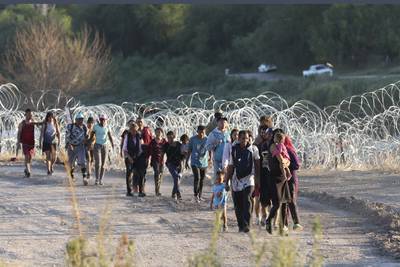 Migrants walk to a U. S.  Border Patrol processing center under International Bridge II in Eagle Pass, Texas, Wednesday, Sept.  20, 2023.  (Jerry Lara / The San Antonio Express-News via AP)