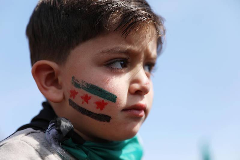 A Syrian boy takes part in a gathering to commemorate the ten years anniversary of the uprising against the Syrian government, in Idlib. EPA