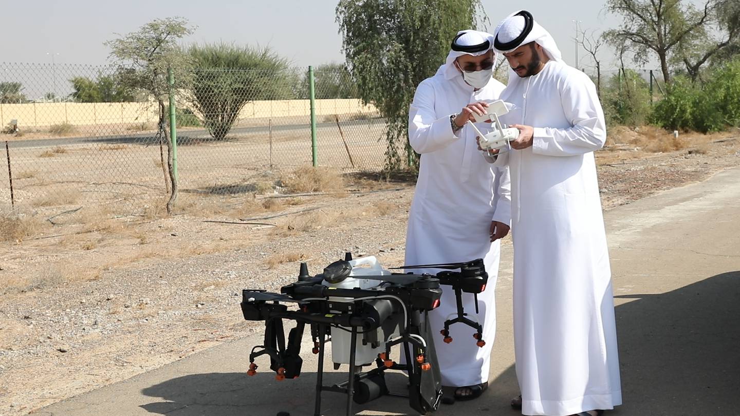 Mohammad and Abdulla Al Moosa with the drone pollination device. Wajod Alkhamis / The National