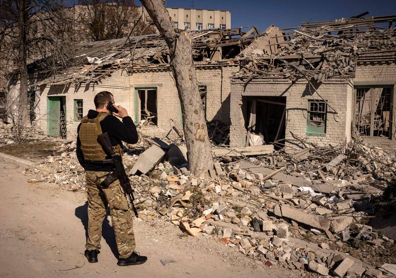 A member of the Ukrainian Territorial Defence Forces stands in front of a damaged house in the city of Zhytomyr, northern Ukraine. AFP