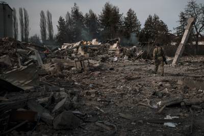 A volunteer of the Ukrainian Territorial Defence Forces walks on the debris of a car wash destroyed by Russian bombing in Baryshivka, east of Kyiv. AP Photo