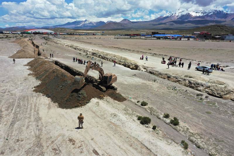 A digger works in a ditch that marks the border between Chile and Bolivia. More than 600 Chilean troops were deployed  to help control migration in four provinces bordering Bolivia and Peru. AFP