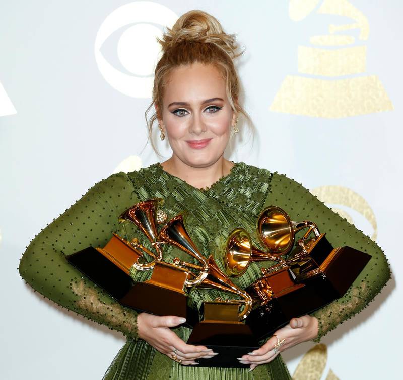 epa05790152 Adele holds up her awards in the press room during the 59th annual Grammy Awards ceremony at the Staples Center in Los Angeles, California, USA, 12 February 2017. Adele won the awards Record Of The Year, Album Of The Year, Song Of The Year, Best Pop Solo Performance and Best Pop Vocal Album, with the album '25' and song 'Hello.'  EPA/MIKE NELSON