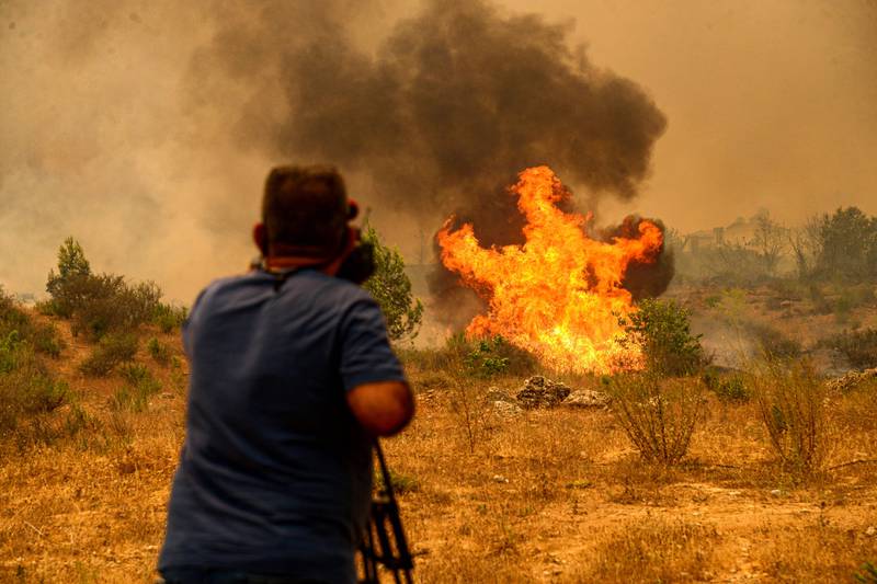 A cameraman films the blazing forest and scrubland near Manavgat, Turkey.