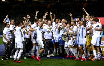Leeds United players celebrate with manager Marcelo Bielsa as they lift the Sky Bet Championship trophy on July 22, 2020 to seal promotion back to the Premier League. PA