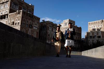 Yemenis walk past historic buildings amid the ongoing Covid-19 pandemic in the old quarter of Sanaa. EPA