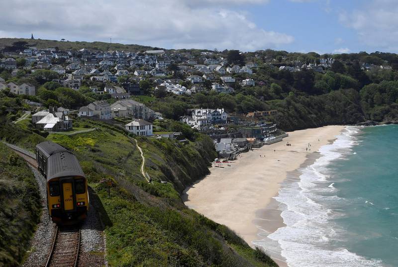 A coastal train passes near the Carbis Bay hotel and beach, where an in-person G7 summit of global leaders is due to take place, in St Ives, Cornwall. Reuters
