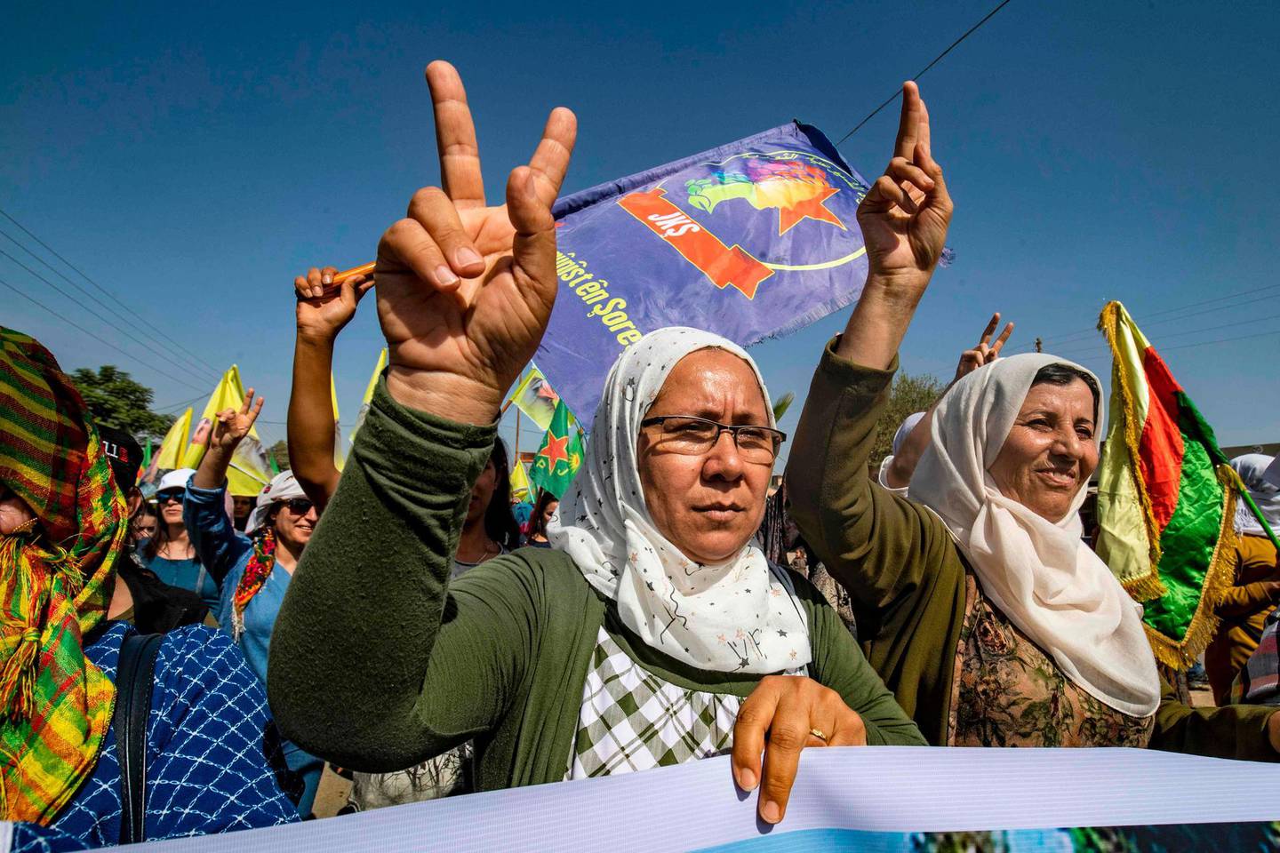 Syrian Kurds flashe the v-sign during a demonstration against Turkish threats in Ras al-Ain town in Syria's Hasakeh province near the Turkish border on October 9, 2019. Syrian Kurds called on Damascus ally Moscow to facilitate "dialogue" with the regime, following threats of a Turkish invasion of northeastern Syria. / AFP / Delil SOULEIMAN
