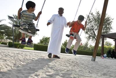 United Arab Emirates -Dubai- May 15, 2009:

HOUSE & HOME: Zubair Ali (cq-al), 53, center, pushes his nephews Houshad Haarith (cq-al), 3, left, and Al Haarith (cq-al), 6, right, on the swings of a playground in the Nad Al Sheba neighborhood in Dubai on Friday, May 15, 2009. Amy Leang/The National
 *** Local Caption ***  amy_051509_nadalsheba_22.jpgamy_051509_nadalsheba_22.jpg
