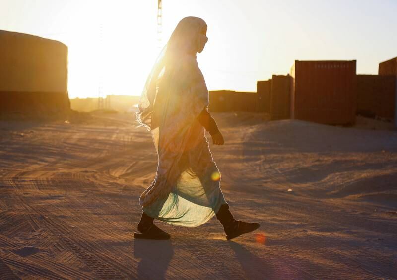 At sunset, a young Sahrawi walks down a street in the camp.