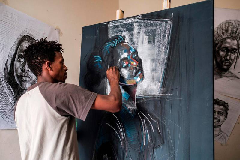 Eritrean artist Nebay Abraha, 23, paints in his room and studio in Addis Ababa on December 6, 2019. AFP
