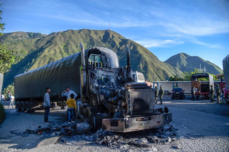 A burnt lorry on the Ocana-Sardinata road in north-east Colombia. Armed men stopped and set fire to five vehicles on the motorway near the border with Venezuela. The practice is widespread in parts of Colombia as a threat and to exert territorial control. AFP