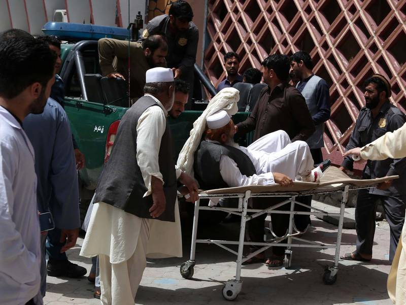 People shift an injured victim to a hospital after militants attacked government buildings in Jalalabad, Afghanistan, on May 13, 2018. Ghulamullah Habibi / EPA