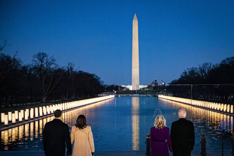 US President-elect Joe Biden, wife Jill Biden, Vice President-elect Kamala Harris and husband Douglas Emhoff stand at the Lincoln Memorial Reflecting Pool during a Covid-19 memorial to lives lost on the National Mall in Washington. Bloomberg