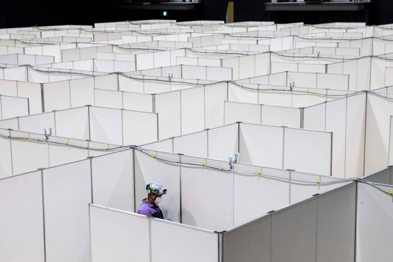 An employee works to set up a medical facility to accomodate coronavirus patients with mild symptoms at the Nippon Foundation Para Arena in Tokyo. Japan's government prepared on May 4 to extend its nationwide state of emergency to the end of May as it braces for a lengthy battle against the pandemic.  AFP