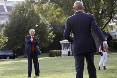 U. President Donald Trump catches a baseball thrown by Mariano Rivera, former pitcher for the New York Yankees. Bloomberg