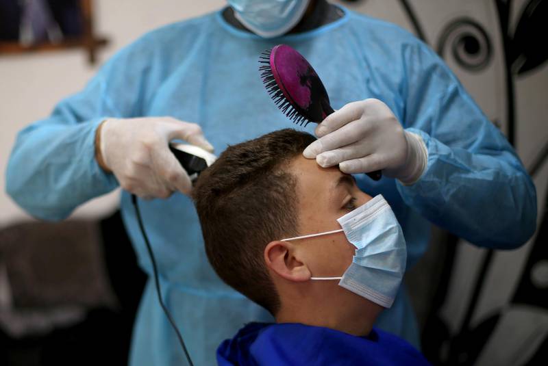A Palestinian customer has his hair cut by a barber in Rafah in the southern Gaza Strip. Reuters