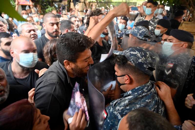 Families and relatives of victims of the August Beirut port explosion clash with Lebanese riot police during a protest outside the Lebanese interior minister's house in Beirut, Lebanon.
