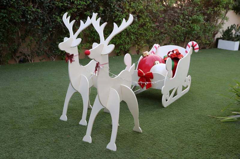 A life-size wooden reindeer and sleigh out back