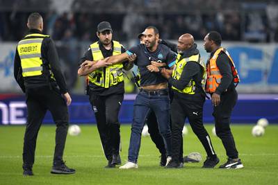 A pitch invader is tackled by security on the pitch. AP