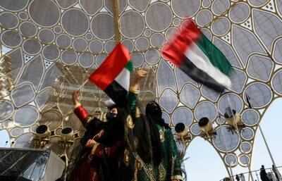 Emirati women wave UAE flags on the 50th National Day at Expo 2020 Dubai last December. EPA