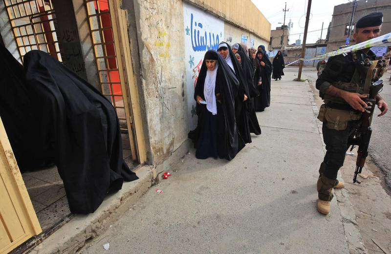 A member of the Iraqi security forces stands guard as women queue in front of a polling station in the Wadi Hajar district of Mosul. Ahmad Al Rubaye / AFP