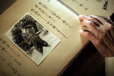 Yoshiomi Yanai looks at his last will and testament with his portrait photo. About one in every five kamikaze planes hit an enemy target.
