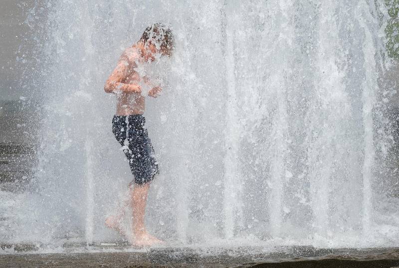 Matthias, 10, who is visiting Berlin with his family from Denmark, cools off at a fountain in the city centre in Berlin, Germany.  Getty Images