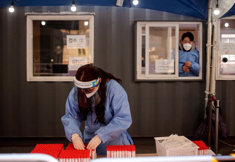 Medical workers prepare to conduct Covid-19 tests at a pop-up screening clinic in front of Seoul Station in South Korea. New coronavirus cases in the country have fallen to 7,000, but critical cases and deaths have surged to record highs of 1,083 and 109, respectively. EPA