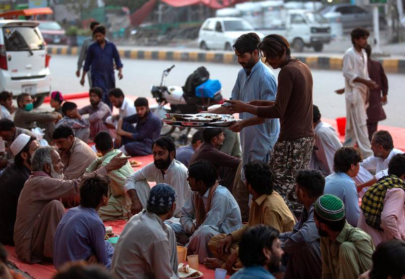Volunteers distribute food among people gather to break their fast at sunset during the Muslims fasting month of Ramadan after the government relaxed a weeks-long lockdown that was enforced to curb the spread of the coronavirus, in Islamabad, Pakistan. AP Photo