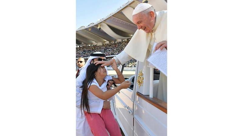 Pope Francis blesses a child before the mass at Zayed Sports City Stadium.