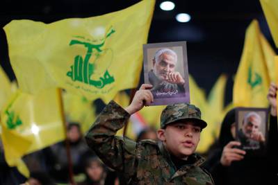 Hezbollah supporters hold pictures of Qassem Suleimani in the southern suburb of Beirut. AP Photo
