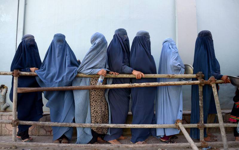In this photo taken on June 12, 2018, Afghan burqa-clad women stands as they wait to receive food donated by a private charity during the Islamic holy month of Ramadan, in Mazar-i-Sharif. Muslims throughout the world are marking the month of Ramadan, the holiest month in the Islamic calendar during which devotees fast from dawn till dus. / AFP / FARSHAD USYAN
