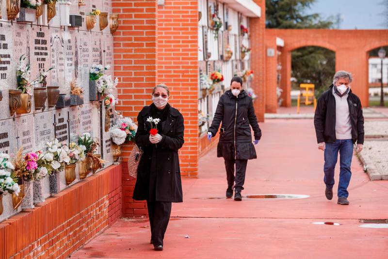 People wearing face masks arrive at the South Municipal cemetery in Madrid. AFP