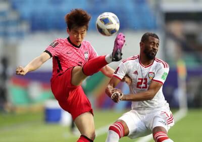 South Korea's Kim Jin-su kicks the ball under pressure from Abdulaziz Hussain of the UAE. Reuters