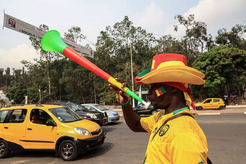 A vendor blows on a vuvuzela while selling Cameroon football attire in the capital Yaounde. The Africa Cup of Nations started on January 9 in Cameroon after a postponement in 2021. AFP