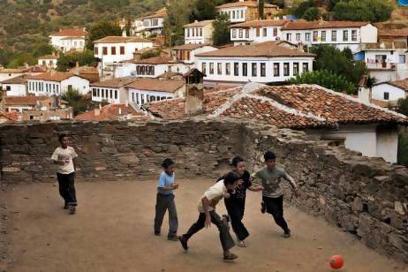 Children play football on the grounds of a church in Sirince, where people are flocking to in December to escape doomsday.