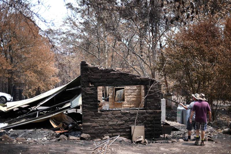 Residents examine damage to their property following bushfires in Budgong National Park. AFP