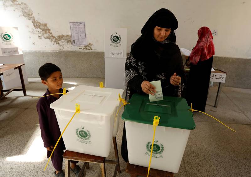 A child watches his mother casts her ballot in Rawalpindi. Reuters