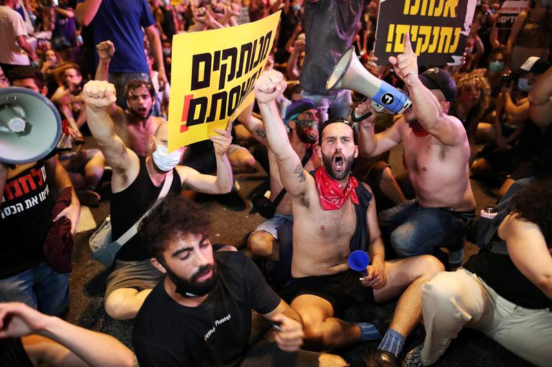 Israelis block a main junction in the city as they protest against the government's response to the financial fallout of the coronavirus crisis in Tel Aviv. REUTERS