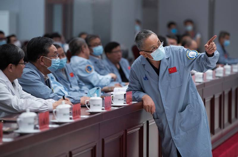 Zhang Rongqiao, right, the chief designer of China's Mars exploration mission, talks with Wu Weiren, second from left, the chief designer of China's lunar exploration project, at the Beijing Aerospace Control Center in Beijing, May 22, 2021. Xinhua via AP