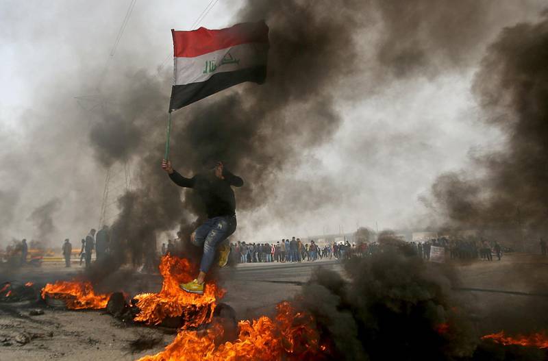 An Iraqi demonstrator jumps over a burning tire during anti-government protests in Basra, Iraq, December 20, 2020. REUTERS/Essam al-Sudani